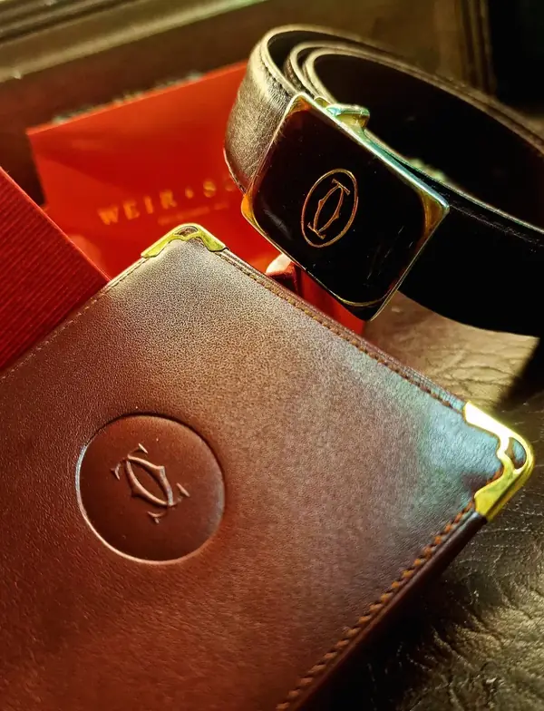 Cartier leather wallet and belt on the bench