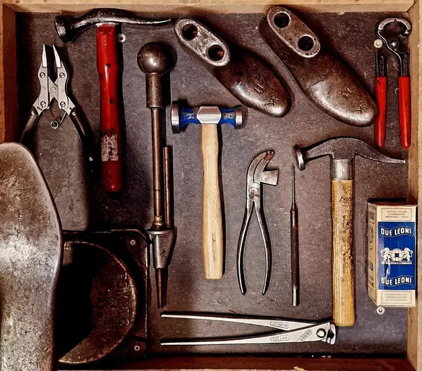Shoe repair tools laid out on a wooden board